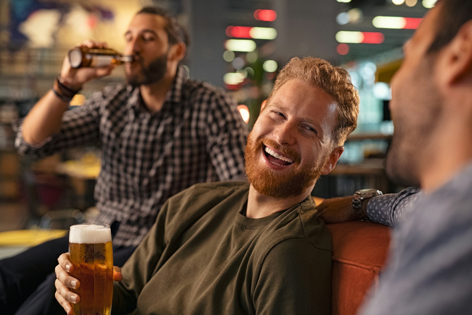 Friends laughing and drinking draft beer